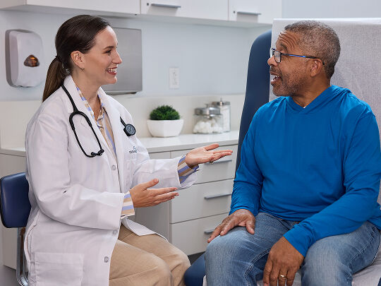 Male patient talking with female doctor at the doctors office.